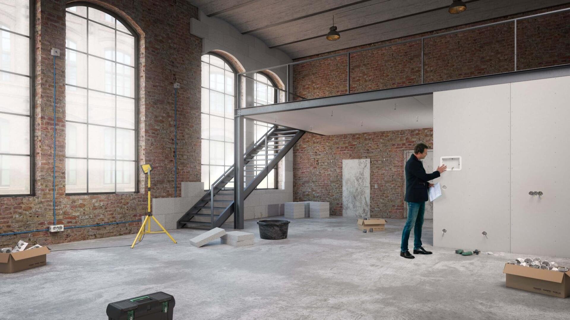Ein Mann im Anzug prüft Baupläne in einem großen, unfertigen Industrieraum mit Ziegelwänden, großen Bogenfenstern, Baumaterialien und Werkzeugen, die überall verstreut sind.