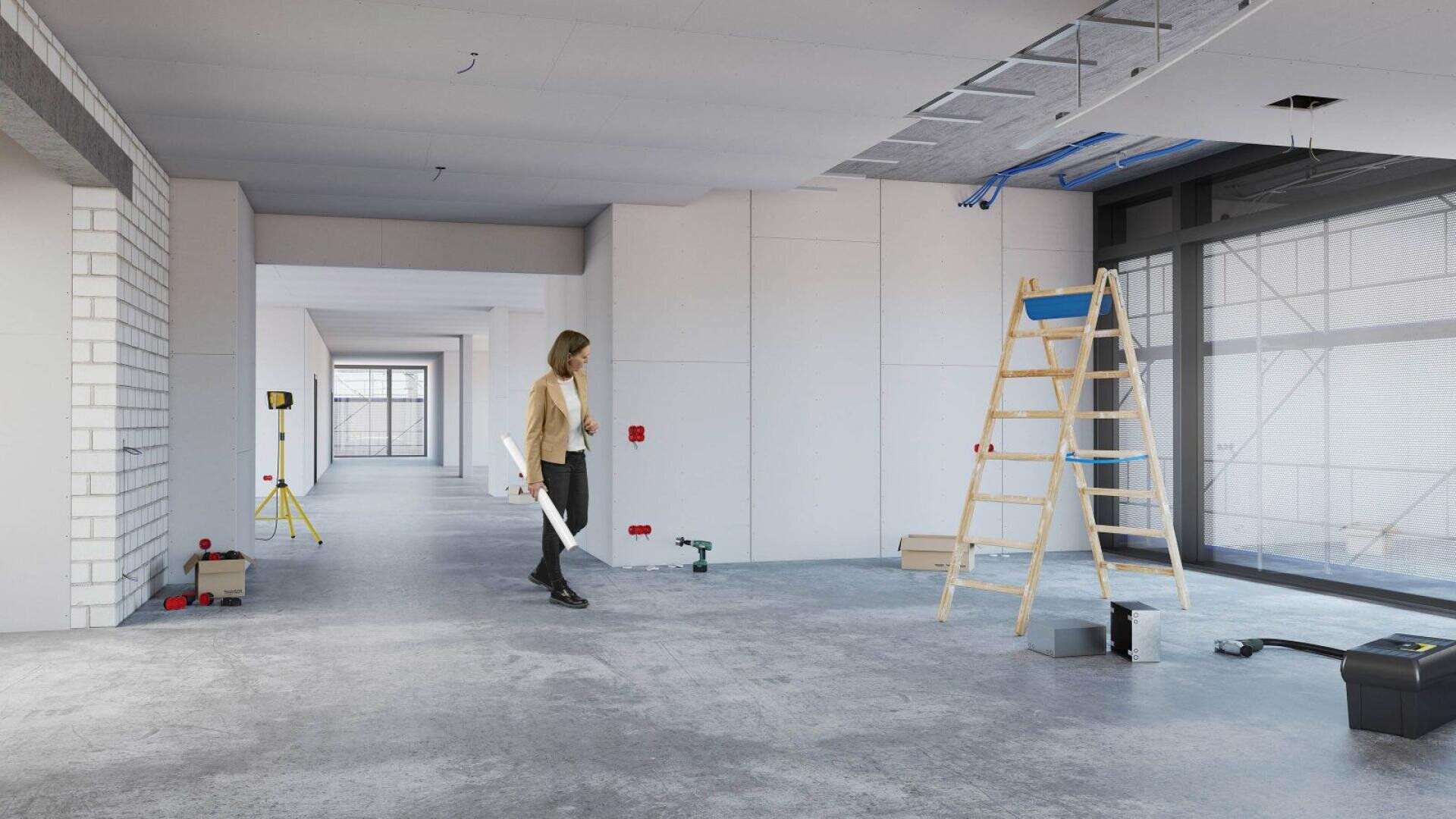Eine Frau geht mit Bauplänen in der Hand durch einen großen, unfertigen Raum, in dem Werkzeuge, eine Leiter und Baumaterialien auf dem Betonboden verstreut sind.